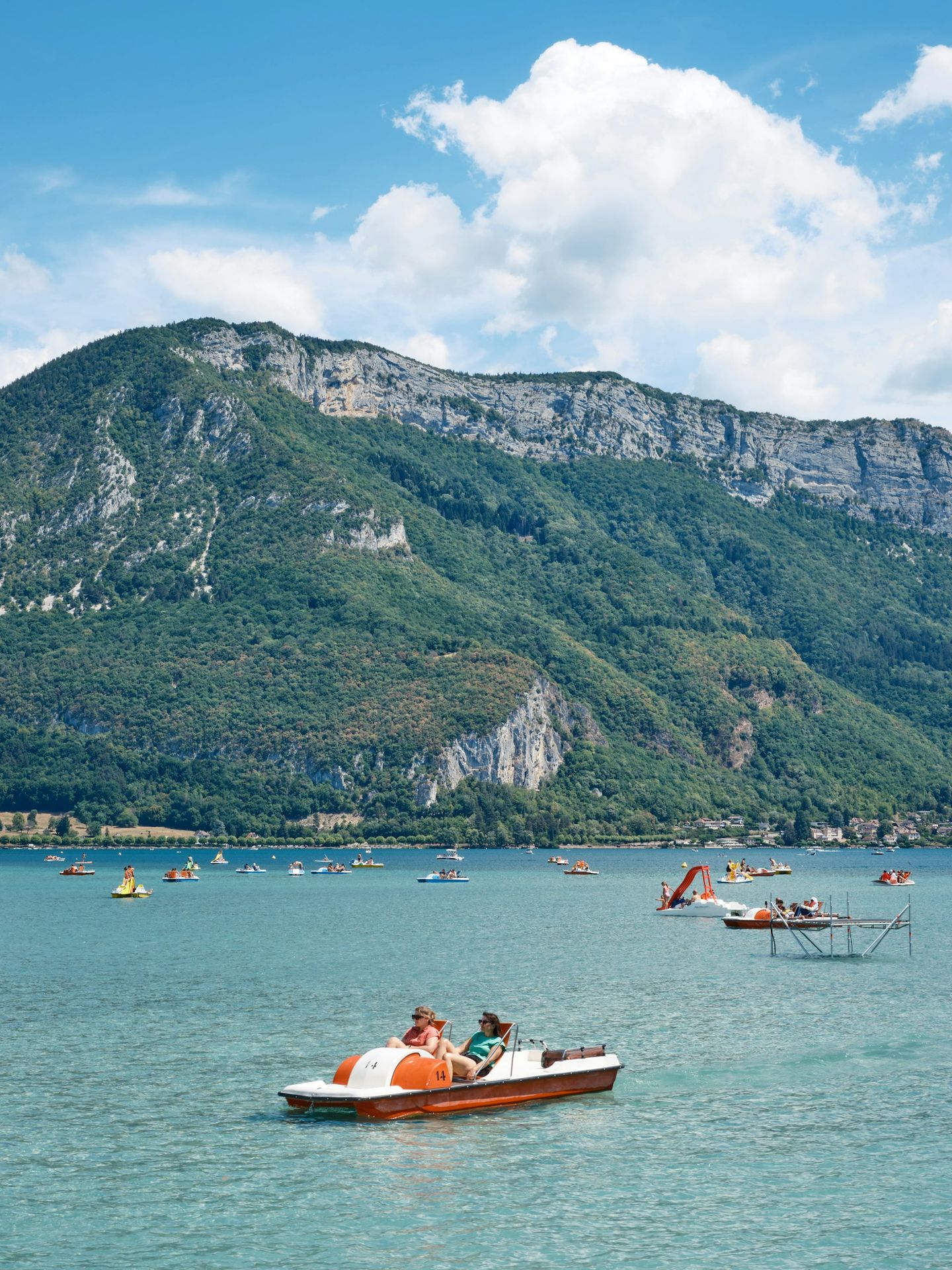 a small boat in a body of water with a mountain in the background